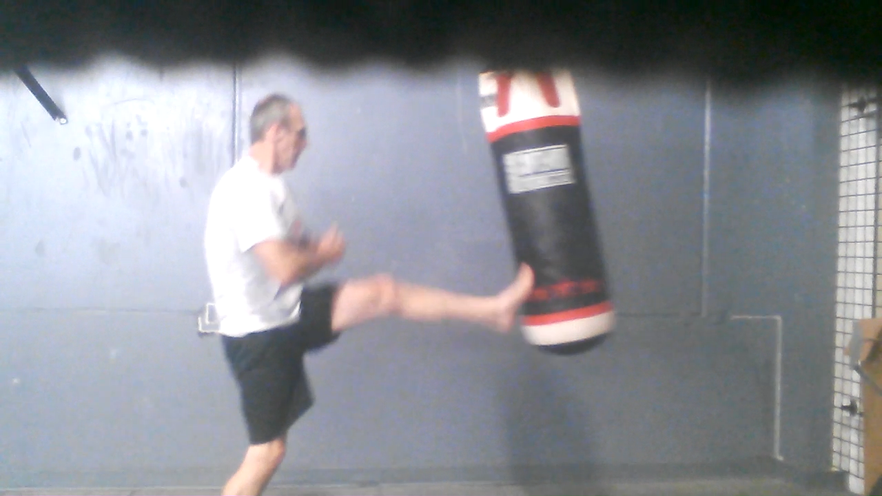 Punching and kicking a heavy bag for fitness